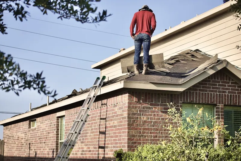 Professional roofer working on a residential roof in Lacona